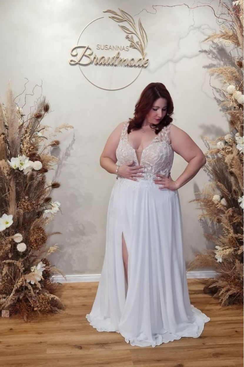 Braut in Brautkleid STEF-FI Curvy mit tiefem V-Ausschnitt, Illusions-Spitze und Beinschlitz im Rock
